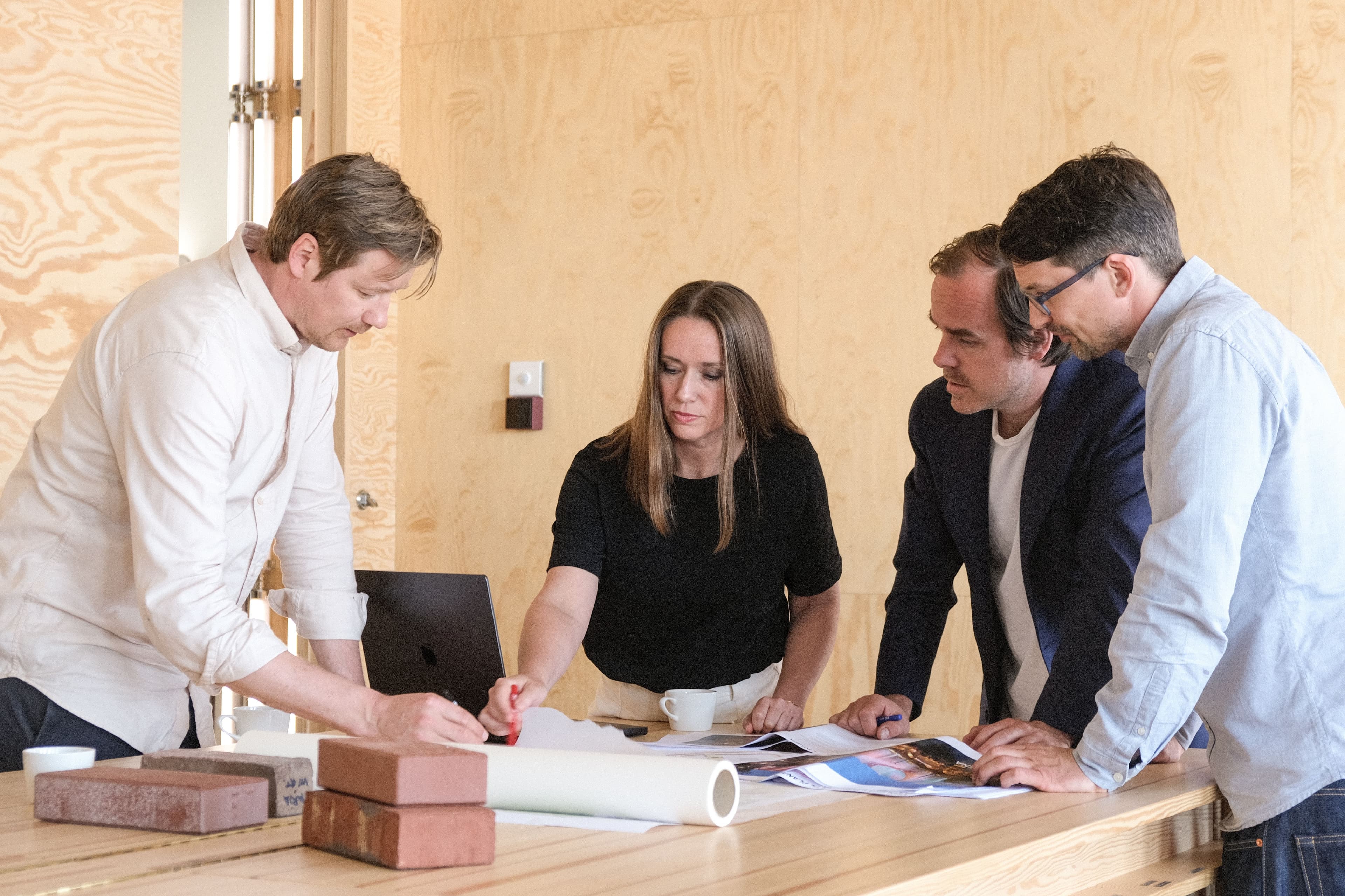 Arkitekter som jobber sammen på et kontor og ser på en tegning.